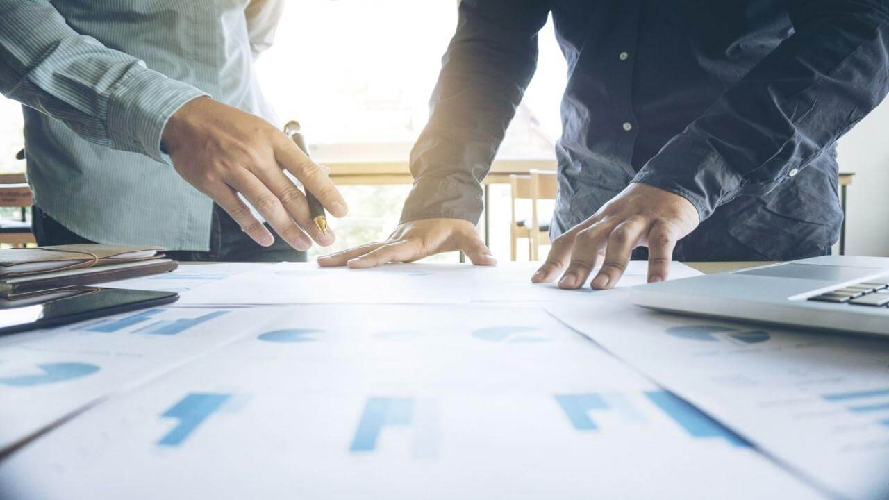 Imagem de duas pessoas realizando analise e planejamento estratégico para negócios.